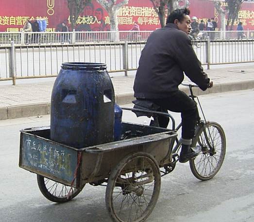 man with full spitoon on a bicycle